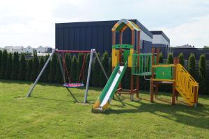 a playground with a slide and a swing set at SŁONECZNE DOMKI in Gąski