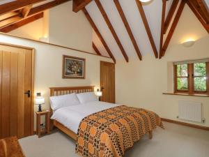 a bedroom with a bed and a wooden ceiling at Stowey Mead Stables in Bristol