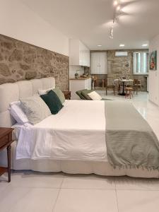 a large white bed in a room with a kitchen at Casa Bossa Nova in Fundão