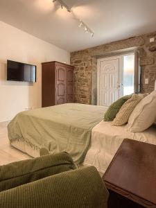 a bedroom with two beds and a tv on the wall at Casa Bossa Nova in Fundão