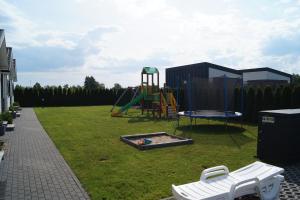 a playground with a slide and a swing set at SŁONECZNE DOMKI in Gąski