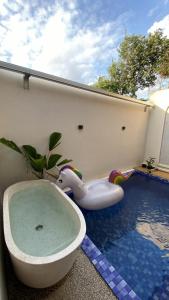 a bath tub sitting next to a swimming pool at Defano Villa Klotok in Yogyakarta