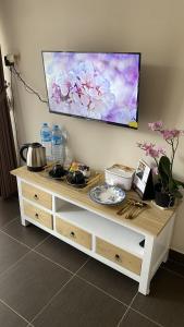 a table with a tv on a wall at Defano Villa Klotok in Yogyakarta