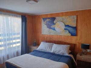 a bedroom with a bed and a painting on the wall at Cabaña Río Blanco in Curacautín