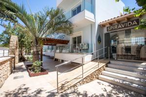 a building with a palm tree in front of it at Perla Marina Hotel in Ialysos