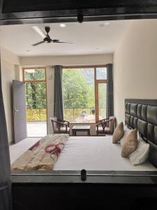 a bedroom with a large bed and a table at Nomad House in Manāli