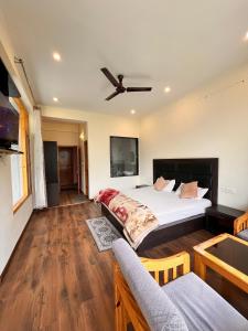 a bedroom with a bed and a ceiling fan at Nomad House in Manāli