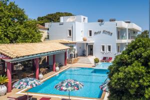 a villa with a swimming pool in front of a house at Perla Marina Hotel in Ialysos