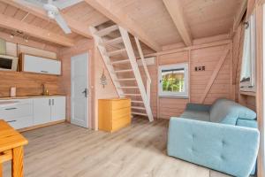 a living room with a blue couch and a kitchen at Sea You Stegna in Stegna