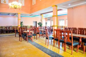 a restaurant with wooden tables and chairs and a chandelier at 6A Resort LTD in Owerri