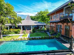 a house with a swimming pool in front of a house at Villa Kampung Kecil Beach Front in Kubu
