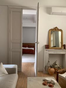 a living room with a couch and a mirror at L'Écrin in Béziers
