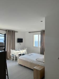 a bedroom with a bed and a table and a desk at Villa Besnik in Sarandë
