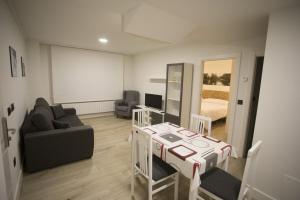a living room with a table and a room with a bed at Apartamentos Canto Encaramado in Gibaja