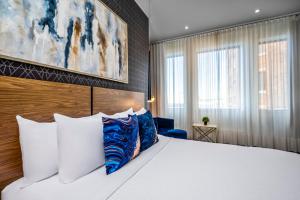a bedroom with a large white bed with blue pillows at Hotel Royal William, an Ascend Collection Hotel in Quebec City +50 photos