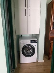 a washer and dryer in a room with a cabinet at Apartament Tudor in Făgăraş