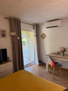a bedroom with a bed and a desk and a window at Cassetta 92 Marie-Pierre in Lumio
