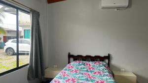 a bedroom with a bed and a window with a car at ACOGEDOR DEPa CON GARAGE PRIVADO in Nueva Loja