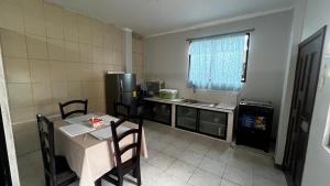 a small kitchen with a table and a refrigerator at ACOGEDOR DEPa CON GARAGE PRIVADO in Nueva Loja +3 photos