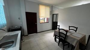 a kitchen and dining room with a table and a sink at ACOGEDOR DEPa CON GARAGE PRIVADO in Nueva Loja