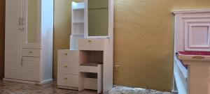a closet with a white cabinet and a shelf at Michenzani rooms apartment in Ngambo +1 photo