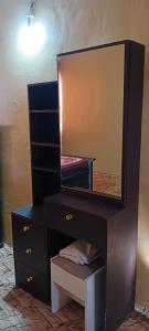 a black dresser with a mirror on top of it at Michenzani rooms apartment in Ngambo