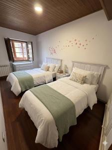 two beds sitting next to each other in a bedroom at Apartamentos El Cuetu in Llanes