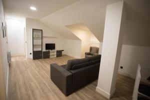 a living room with a couch and a television at Apartamentos Canto Encaramado in Gibaja