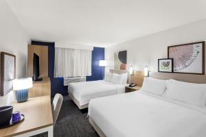 a hotel room with two beds and a desk at Spark By Hilton Beckley in Beckley