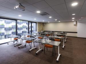a classroom with tables and chairs and a whiteboard at Mercure Bale Mulhouse Aeroport in Blotzheim +95 photos