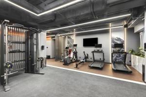 a gym with cardio equipment and a flat screen tv at Radisson RED Auckland in Auckland