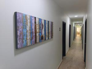 a painting hanging on a wall next to a hallway at Hotel Nella Mar in Puerto Colombia +2 photos