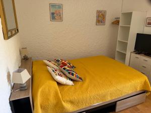 a bedroom with a yellow bed with pillows on it at Cassetta 92 Marie-Pierre in Lumio