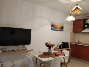 a living room with a tv and a table with chairs at Apartamentos Amy 3 con vista a mar in Palos de la Frontera