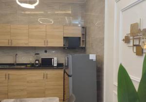 a kitchen with a white refrigerator and wooden cabinets at STUDIO Meublée à Gbodjè in Porto-Novo