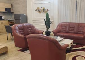 a living room with two leather chairs and a table at STUDIO Meublée à Gbodjè in Porto-Novo +7 photos