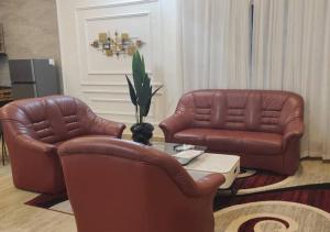 two brown leather chairs and a table in a living room at STUDIO Meublée à Gbodjè in Porto-Novo