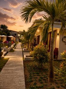 a pathway with palm trees in front of a building at Qwank Kuta Lombok in Kuta Lombok