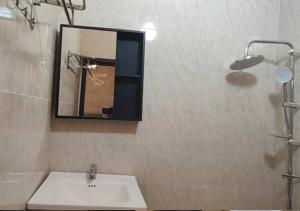 a bathroom with a sink and a mirror and a shower at STUDIO Meublée à Gbodjè in Porto-Novo