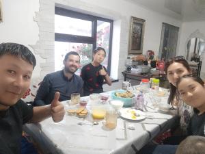 a group of people sitting around a table eating food at Alima in Ottuk