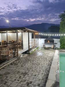 a building with a patio with a table and a grill at Dilijan Rest - Comfortable rooms & Pool in Dilijan