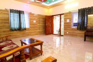 a living room with wooden walls and a table at Malar Resort in Wodapatti +15 photos