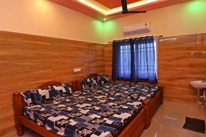 a bedroom with a bed in a room with wooden walls at Malar Resort in Wodapatti