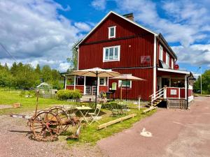 a red barn with an umbrella and a wheel at Linda's Apartment in Sörsjön