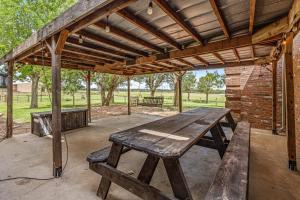 a wooden picnic table under a pavilion in a park at Crooked F Ranch in Stephenville