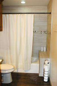 a bathroom with a shower curtain and a toilet at Crooked F Ranch in Stephenville +8 photos