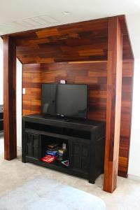 a entertainment center with a flat screen tv on a wooden wall at Crooked F Ranch in Stephenville