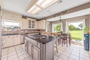 a kitchen with white cabinets and a large island with a counter top at Crooked F Ranch in Stephenville