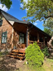 a log cabin with a porch and stairs to the front at Dębowy Zakątek in Dębowo