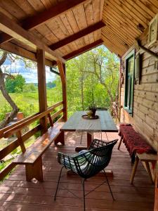 a wooden deck with a table and bench on a cabin at Dębowy Zakątek in Dębowo